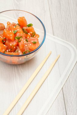 Yeşil soğanlı Hawaii somonu ve çubuklu cam kasede susam tohumu. Üst Manzara. Organik deniz ürünleri