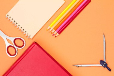 Kitap, makas, defter, renkli kalemler ve pusula pembe bir arka plan üzerinde. Üstten görünüm kopya alanı ile. Geri okul kavramı. Okul malzemeleri. Pastel renkler
