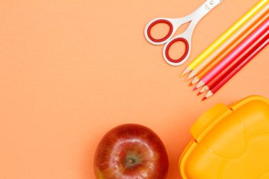 Okul malzemeleri. Apple, makas, kalem, renkli kalemler ve beslenme çantası pembe bir arka plan üzerinde hissetti. Üstten görünüm kopya alanı ile. Geri okul kavramı. Pastel renkler