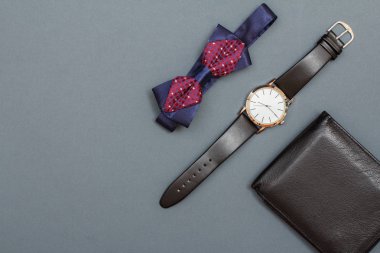 Fiyonk, seyretmek ile siyah deri kayışı ve gri arka plan üzerinde deri çanta. Erkekler için aksesuarlar. Üstten görünüm