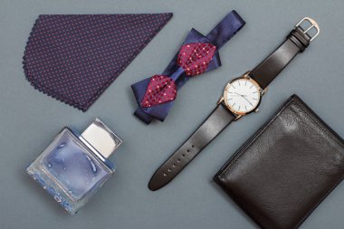 Erkekler, mendil, papyon, Köln izlemek bir siyah deri kayışı ve gri arka plan üzerinde deri çanta. Erkekler için aksesuarlar. Üstten görünüm