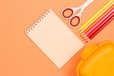 Defter, makas, renkli kalemler ve beslenme çantası pembe bir arka plan üzerinde. Üstten görünüm kopya alanı ile. Geri okul kavramı. Okul malzemeleri. Pastel renkler