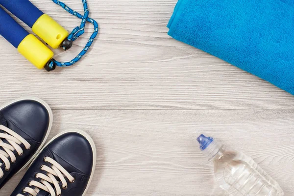 Different tools for fitness with bottle of water in room or gym on grey floor