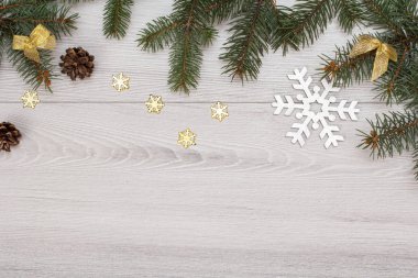 Noel dekorasyonu. Köknar ağacı dalları koniler ve gri arka plan üzerinde dekoratif kar taneleri ile. Üstten görünüm. Noel tebrik kartı kavramı.