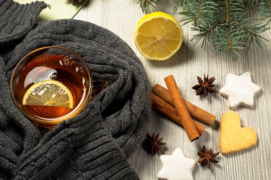 Dilim limon ile çay Kupası yün atkı gingerbread çerezleri yıldız ve kalp şekli, Doğal Çam ağaç dalları ve tarçın, anasonu ahşap kurullarında tamamladı. Renk efekti tonlama.