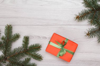 Noel dekorasyonu. Hediye kutusu, gri ahşap kurullarında köknar ağacı dalları. Üstten görünüm. Noel tebrik kartı kavramı.