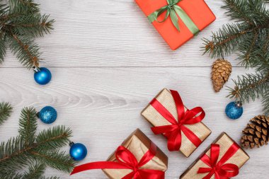 Noel dekorasyonu. Hediye kutuları, koni ve Noel oyuncaklar gri ahşap kurullarında köknar ağacı dalları. Üstten görünüm. Noel tebrik kartı kavramı.