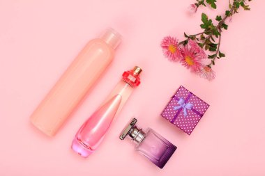 Hediye kutusu, şişe parfüm ve pembe bir arka plan üzerinde şampuan. Kadın kozmetik ve aksesuarları. Üstten görünüm.