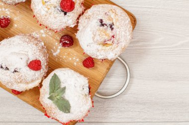 Ev yapımı meyve kek pudra şekeri ve taze ahududu ahşap kesme tahtası üzerine serpilir. Noel tatlılar ve pastalar. Kopya alanı ile üstten görünüm.
