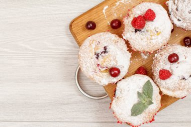 Ev yapımı meyve kek pudra şekeri ve taze ahududu ahşap kesme tahtası üzerine serpilir. Noel tatlılar ve pastalar. Kopya alanı ile üstten görünüm.