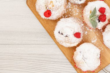 Ev yapımı meyve kek pudra şekeri ve taze ahududu ahşap kesme tahtası üzerine serpilir. Noel tatlılar ve pastalar. Kopya alanı ile üstten görünüm.