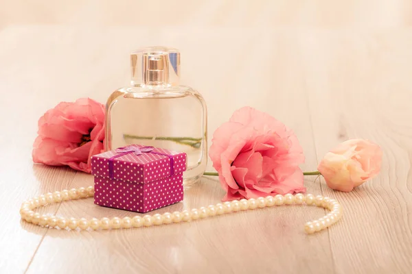 Butelkę Perfum Kobiet Pudełko Koraliki Sznurku Kwiaty Różowym Tle Koncepcja — Zdjęcie stockowe