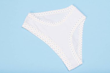 Mavi zemin üzerine beyaz pamuklu iç çamaşırı. Kadın iç çamaşırı ayarlayın. Üstten görünüm.