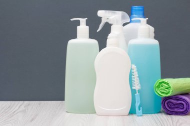 Plastik şişe bulaşık deterjanı, cam ve döşeme temizleyici, deterjan mikrodalga fırın ve soba ve gri arka plan üzerinde çöp torbaları için. Yıkama ve Temizleme kavramı.