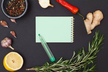 Yemek tarifi için kopya alanı malzemelerle. Zencefil kökü, chili biber, sarımsak, soğan, limon, yenibahar biber cam kase ve siyah arka plan üzerine biberiye. Üstten görünüm.
