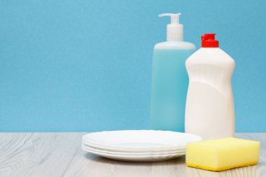 Döşeme Temizleyici, bulaşık deterjanı, cam ve plastik şişe tabak temiz ve mavi zemin üzerine sünger. Yıkama ve Temizleme kavramı.