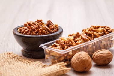 Soyulmuş ceviz taş kase ve Plastik Konteyner ile tutuyordu. Yararlı besleyici protein ürün. Sığ derinlik-in tarla.