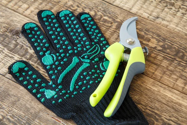 木板上的花园黑色手套和修剪器 园林工具和设备 — 图库照片