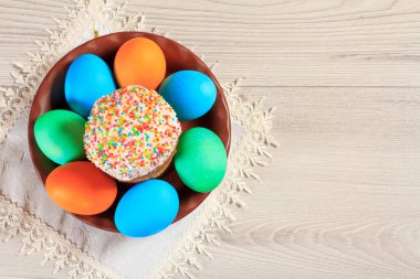 Paskalya kek ve peçete ve ahşap plakalar ile bir tabakta boyalı yumurta. Geleneksel Ortodoks Hıristiyan Paskalya gıda. Üstten görünüm.