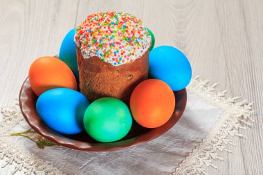 Paskalya kek ve peçete ve ahşap plakalar ile bir tabakta boyalı yumurta. Geleneksel Ortodoks Hıristiyan Paskalya yemek.