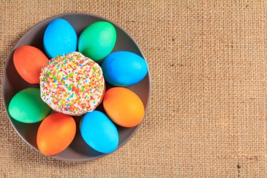 Paskalya kek ve bir plaka üzerinde boyalı yumurta ile arka planda tutuyordu. Geleneksel Ortodoks Hıristiyan Paskalya gıda. Üstten görünüm.