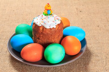 Paskalya kek ve bir plaka üzerinde boyalı yumurta ile arka planda tutuyordu. Geleneksel Ortodoks Hıristiyan Paskalya yemek.