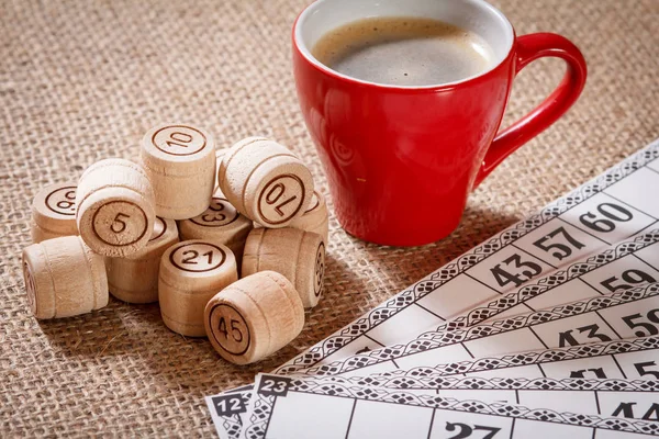 Loto de jeu de société sur sac. Barils de loto en bois et cartes de jeu avec tasse de café . — Photo