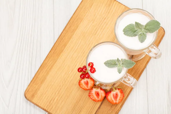 Iogurte de morango delicioso com folhas de hortelã em copos . — Fotografia de Stock