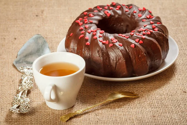 Küçük karamel kalpler ile dekore edilmiş çay ve ev yapımı çikolatalı kek fincan. — Stok fotoğraf