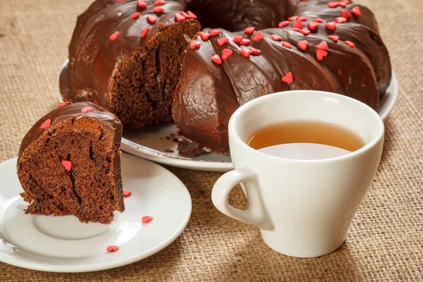 Ev yapımı çikolatalı kek küçük karamel kalpler ve çay fincan ile dekore. — Stok fotoğraf
