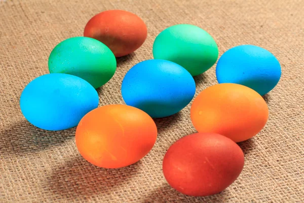 Закрашенные яйца на мешковине в качестве фона . — стоковое фото