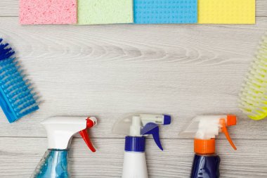 Temizlik için deterjan, renkli mikrofiber peçeteler ve sentetik fırçaşişeleri.