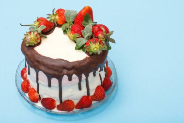 Cam plaka üzerinde taze çilek ile dekore edilmiş ev yapımı çikolatalı kek.