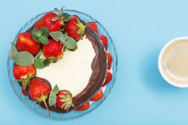 Cam tabak ve kahve fincan taze çilek ile dekore edilmiş ev yapımı çikolatalı kek.