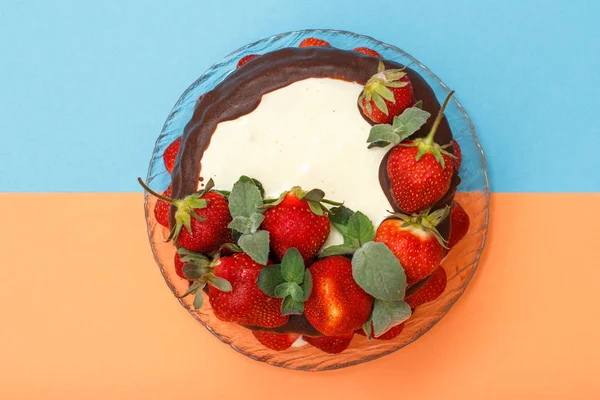 Домашній шоколадний торт, прикрашений свіжою полуницею на скляній тарілці та кольоровому фоні . — стокове фото