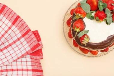 Mutfak peçetesi ile cam tabakta taze çilek ile dekore edilmiş ev yapımı çikolatalı kek.