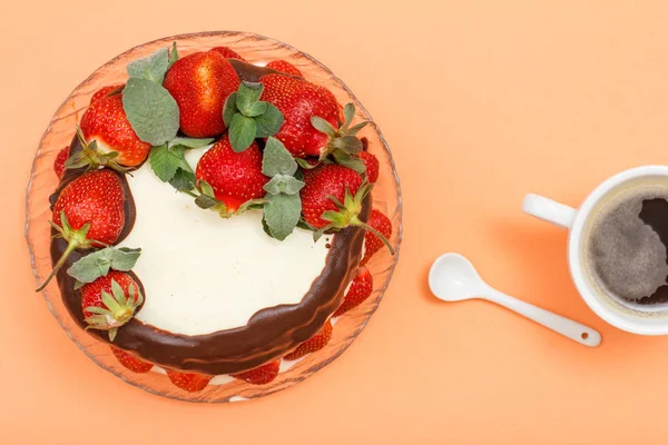 Домашній шоколадний торт, прикрашений свіжою полуницею на скляній тарілці та чашкою кави . — стокове фото