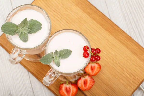 Iogurte de morango delicioso com folhas de hortelã em copos . — Fotografia de Stock