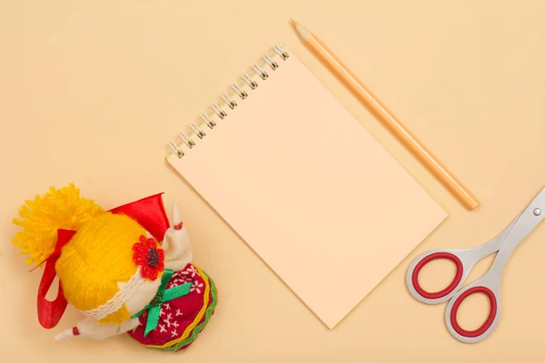 Material escolar. Caderno, lápis de cor, tesoura e boneca em fundo bege . — Fotografia de Stock