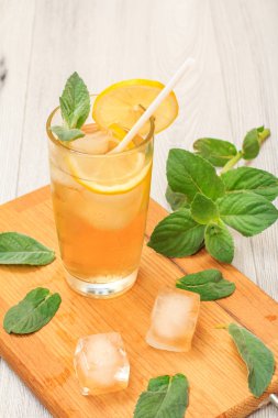 Uzun bir bardak nane ile dekore edilmiş, buz ve limon dilimleri ile yaz limonata ferahlatıcı soğuk bırakır.