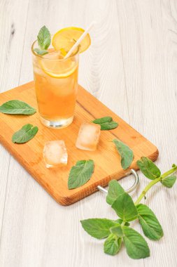 Uzun bir bardak nane ile dekore edilmiş, buz ve limon dilimleri ile yaz limonata ferahlatıcı soğuk bırakır.