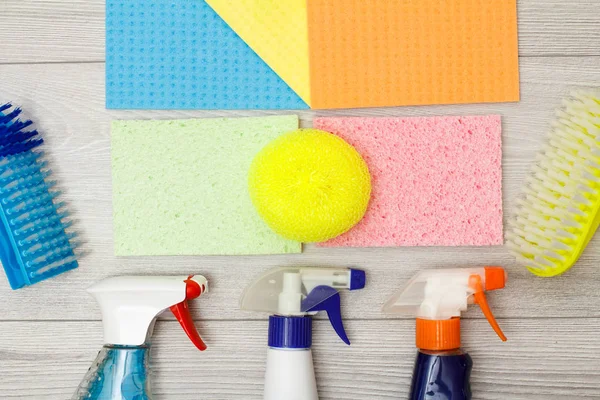 Bottles of detergent, color microfiber napkins, synthetic sponge and brushes for cleaning