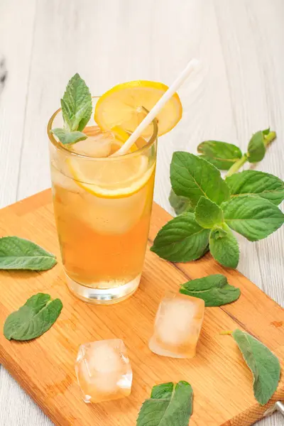 Uzun bir bardak nane ile dekore edilmiş, buz ve limon dilimleri ile yaz limonata ferahlatıcı soğuk bırakır.