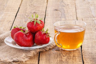 Cam kase çay ve kırmızı olgun çilek bardak fincan.