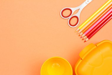 Makas, renkli kalemler, plastik bardak ve öğle yemeği kutusu. Okul malzemeleri.