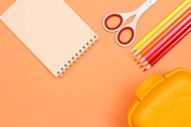 Defter, makas, renkli kalemler ve yemek kutusu.