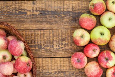 Hasır sepet ve eski ahşap tahtalar kırmızı elma.