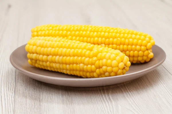Порцелянова тарілка з вареною кукурудзою на столі . — стокове фото