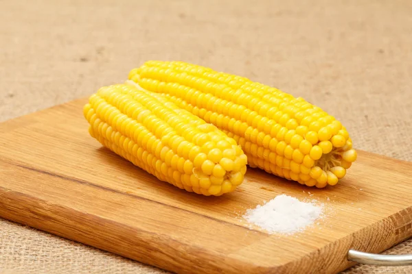 Vágódeszka főtt kukoricával, asztalon. — Stock Fotó
