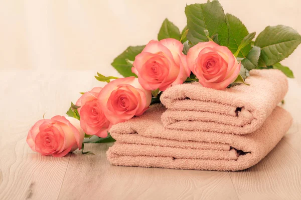 Montón de toallas de rizo suave con flores en tablas de madera — Foto de Stock